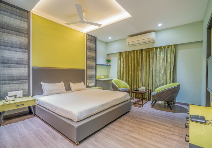 Clean and comfortable Deluxe room with lime accent wall