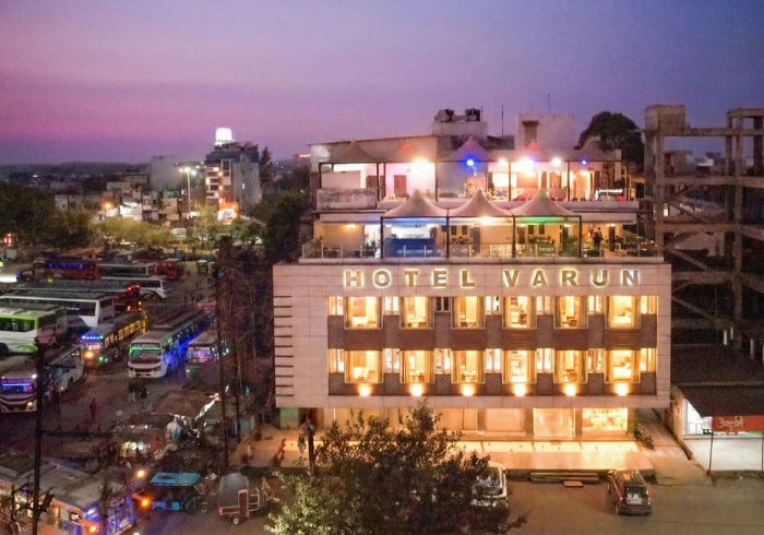 Hotel Varun at dusk with the rooftop restaurant lit up