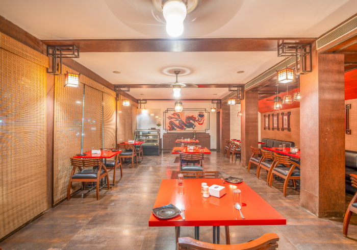 Small party space with red tables at Hotel Varun Guna