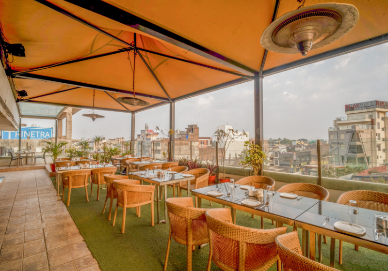 Open-air terrace restaurant with canopy and city views